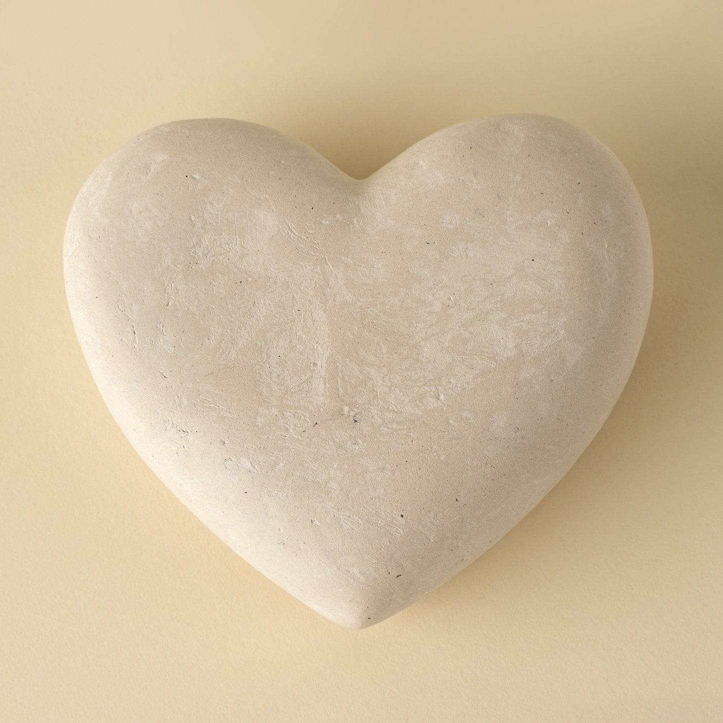Heart-shaped stone on a beige background