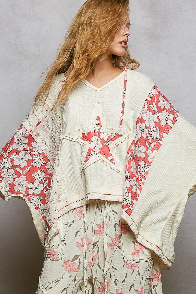 Woman wearing a floral kimono-style garment against a plain background