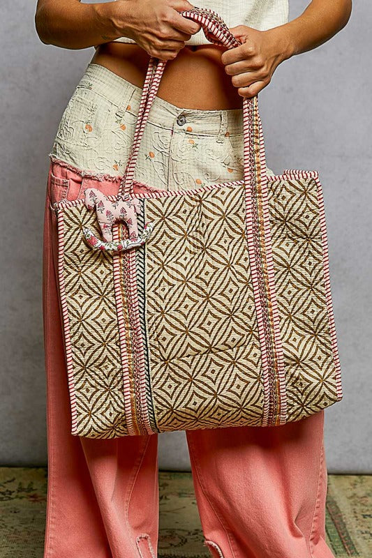 women holding a quilted patterned tote bag