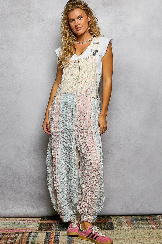 Woman wearing a patterned overalls against a gray background