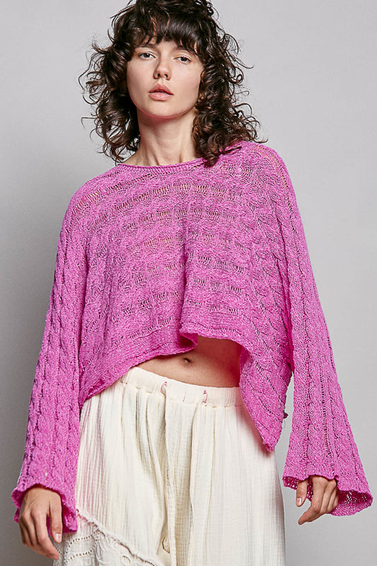 women wearing a bright pink knit sweater on a grey background
