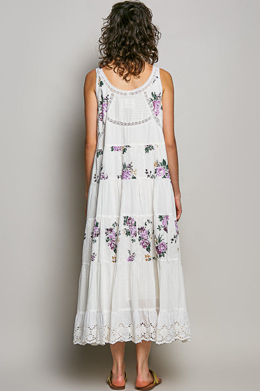 Woman wearing a white floral dress against a plain background