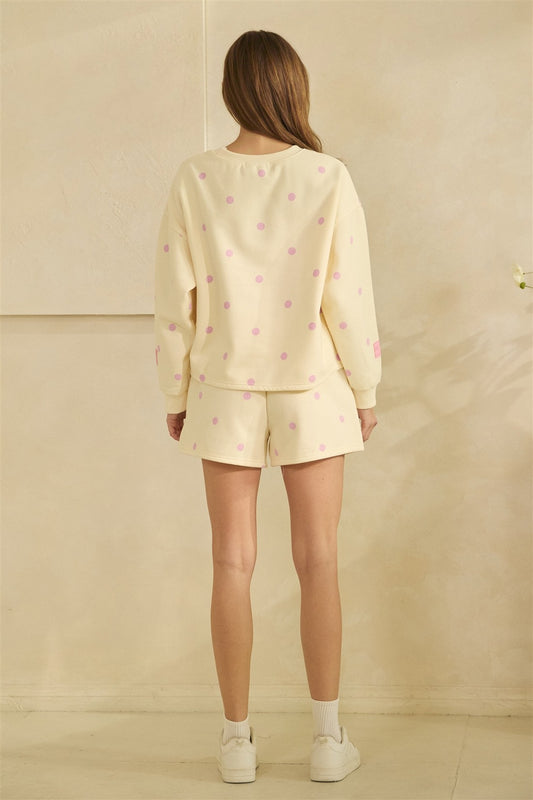 Woman wearing a light yellow pajama set with small patterns against a beige background