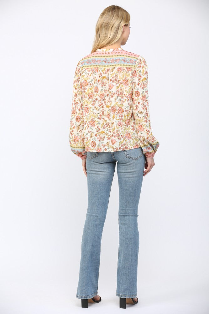 Women wearing a floral print blouse and blue jeans on a white background.