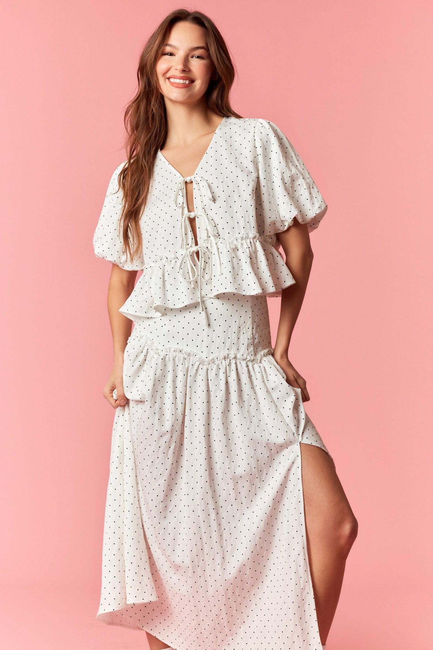 Woman wearing a white floral dress on a pink background