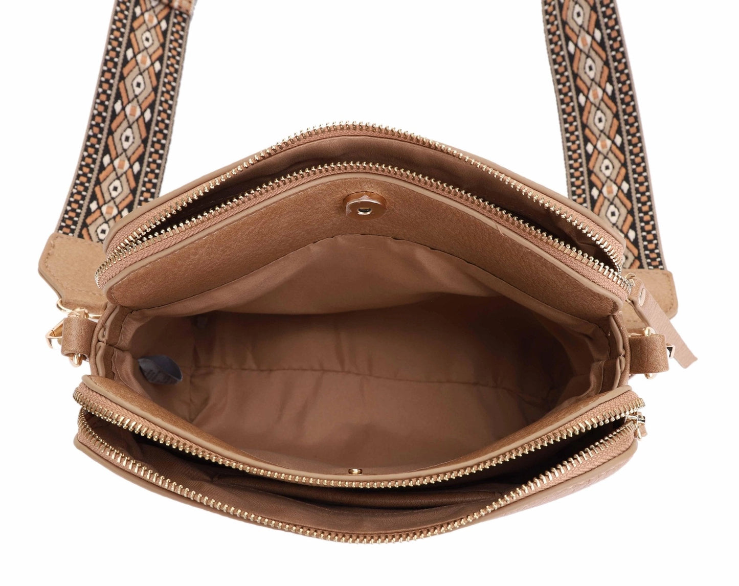 The interior of a 3 compartment crossbody bag with a boho guitar strap.