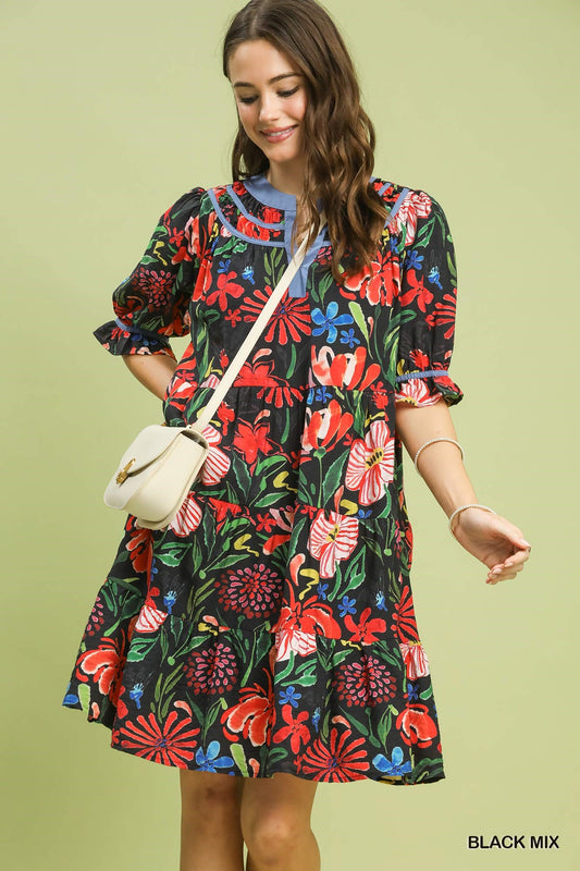 Woman wearing a colorful floral dress against a light green background