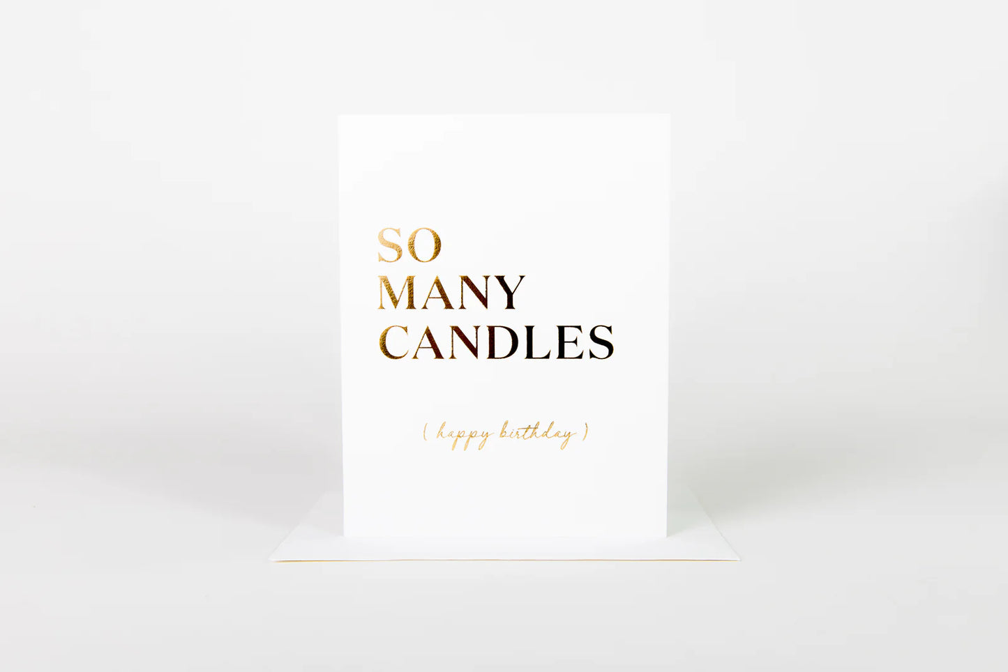 White card with gold text 'SO MANY CANDLES' on a white background