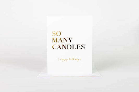 White card with gold text 'SO MANY CANDLES' on a white background