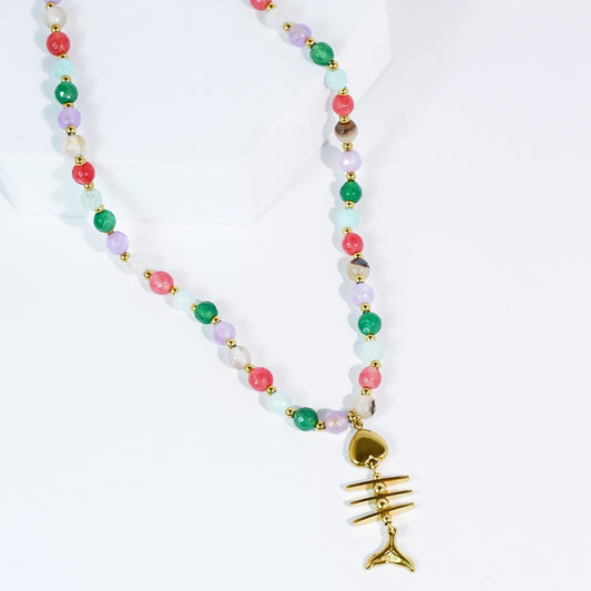 a beaded necklace with a fishbone gold pendant on a white background.