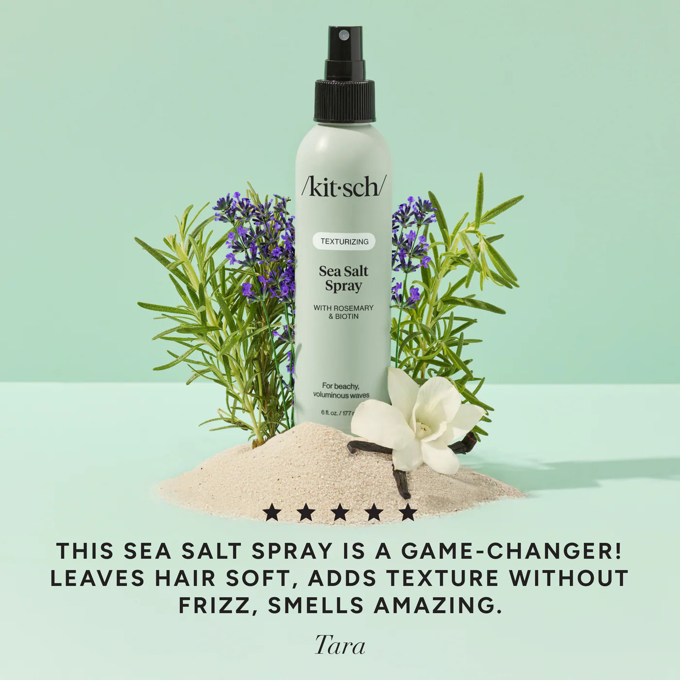 Kitsch Sea Salt Spray bottle with herbs and sand on a light green background