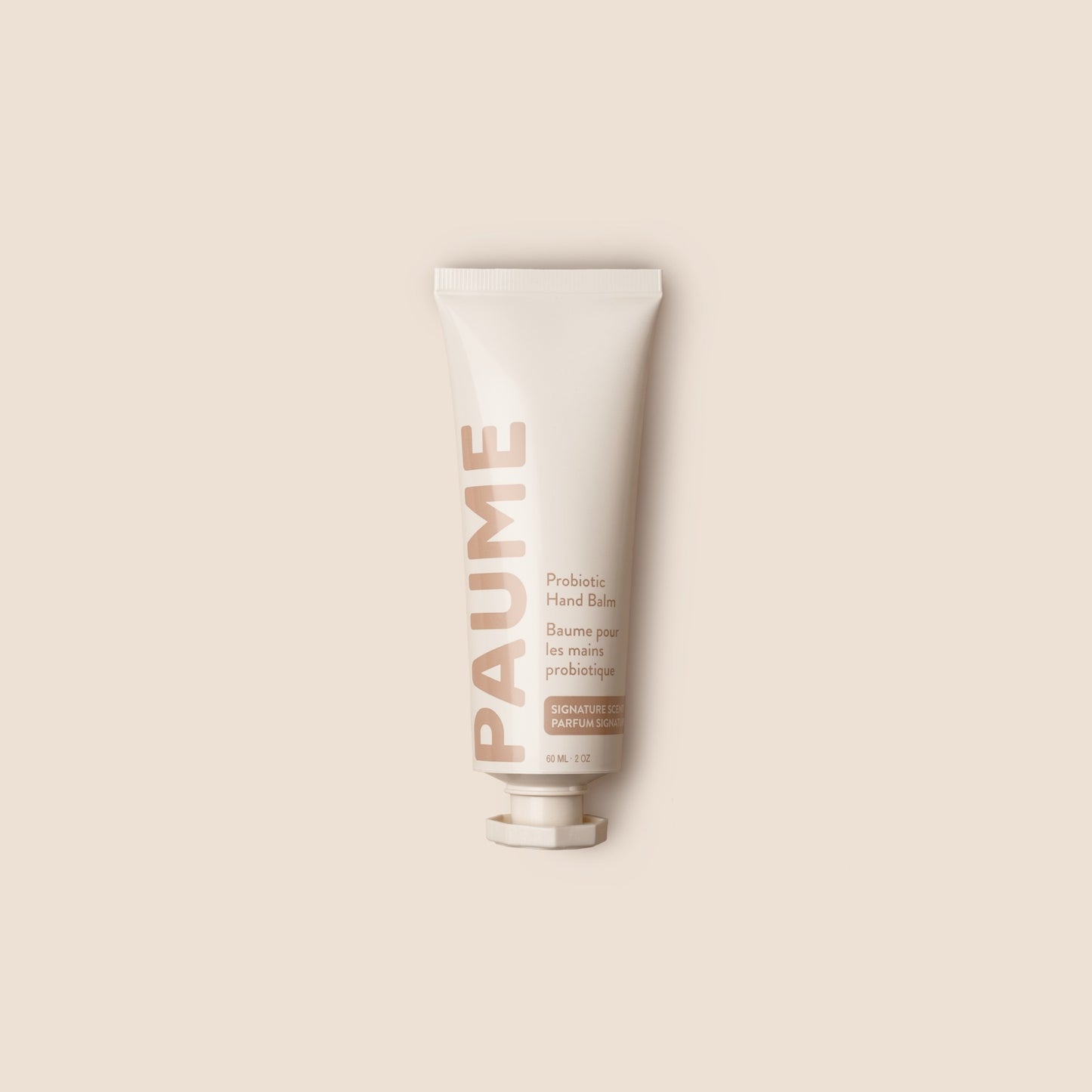 Tube of 'Paume' hand balm on a beige background