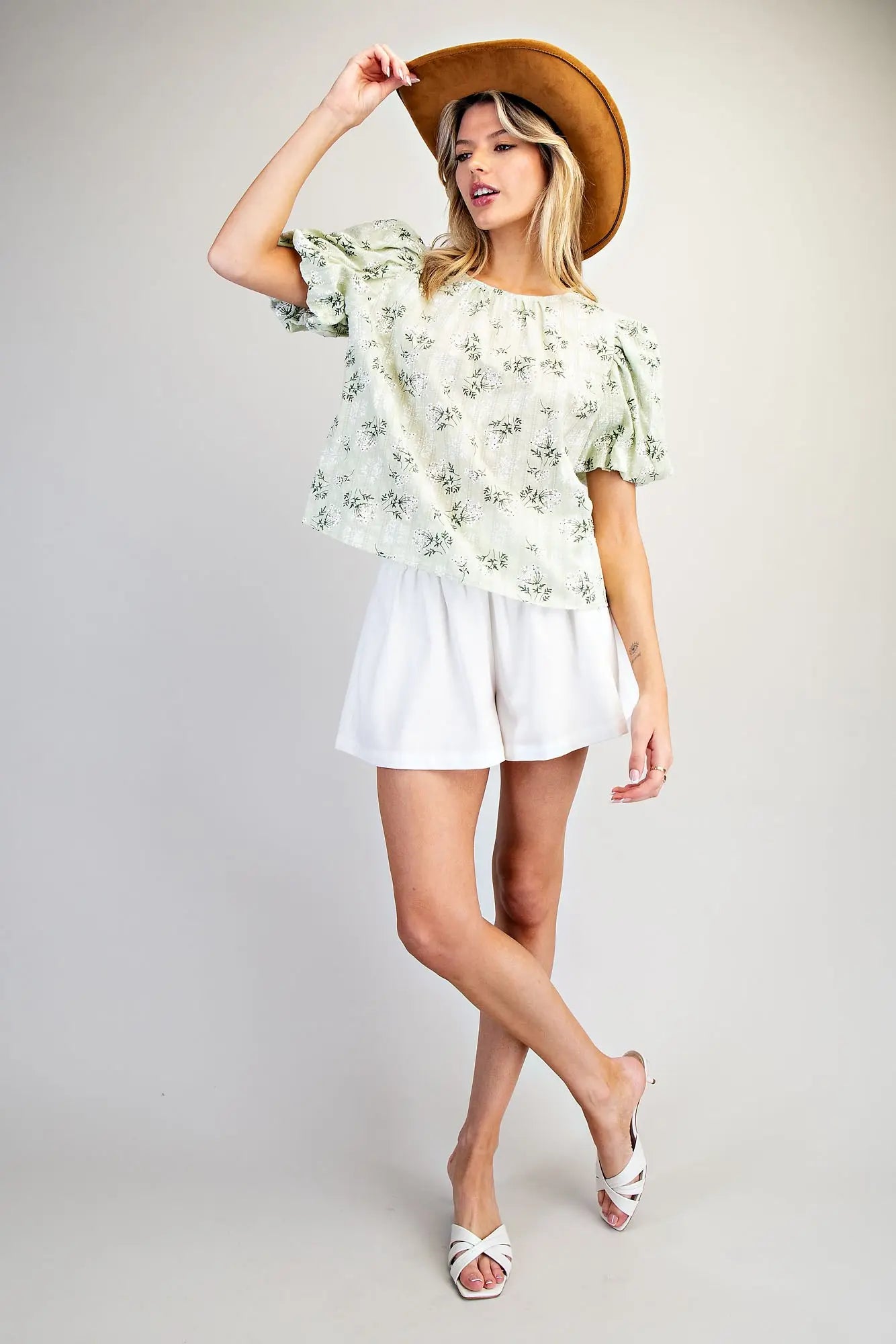 Women wearing a green floral blouse with white shorts