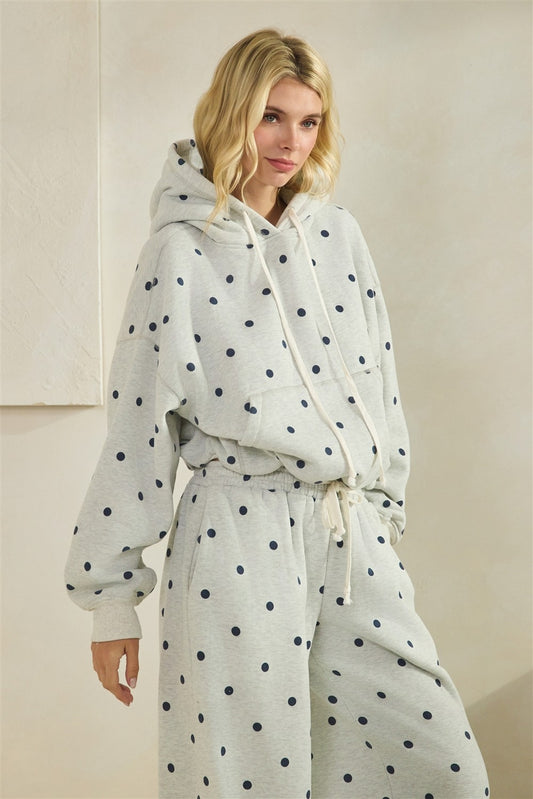 Woman wearing a polka dot hoodie and pants set in a neutral setting