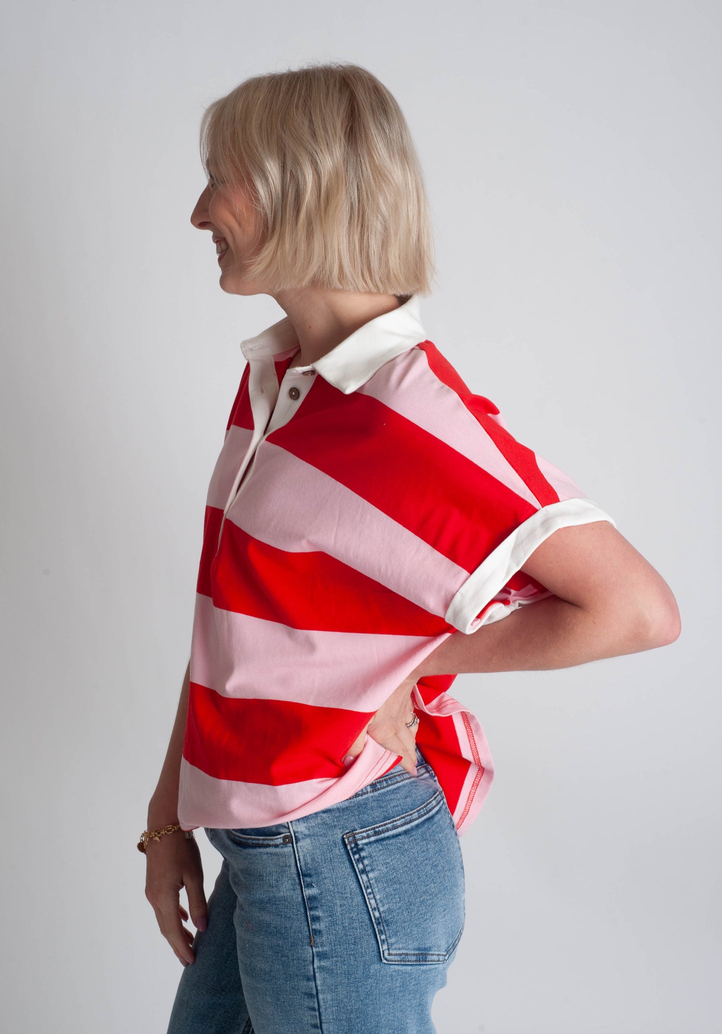 Woman wearing a red and white striped shirt with a plain background