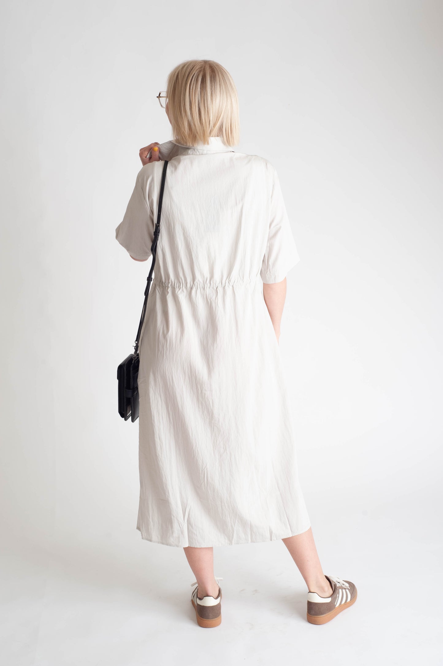 women wearing a button up dress on a white background.