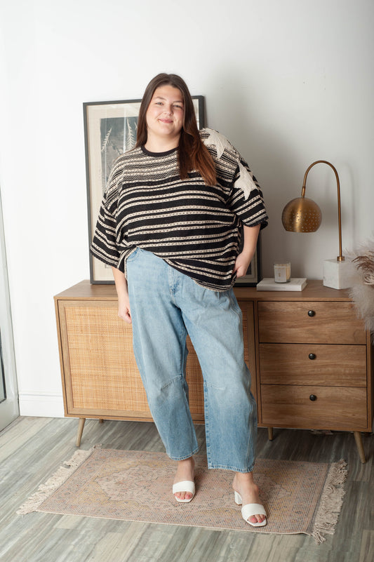 Woman standing in a room with wooden furniture and decor