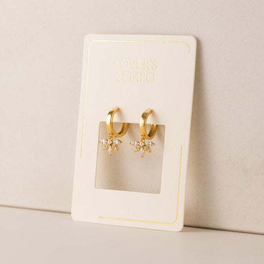 Gold hoop earrings on a branded card with a beige background