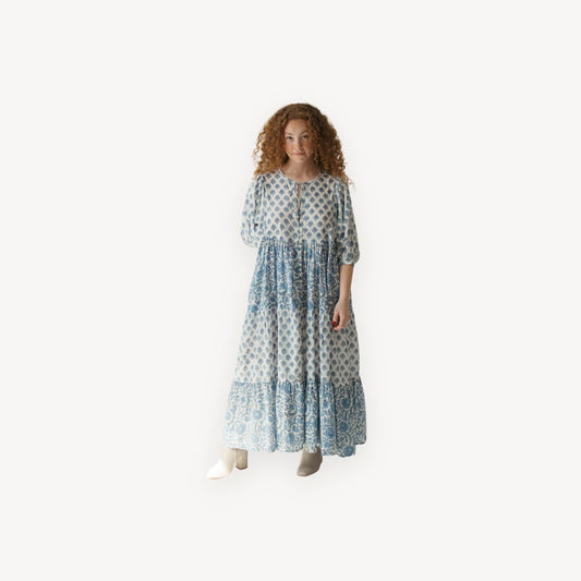 Woman wearing a long, patterned dress on a white background