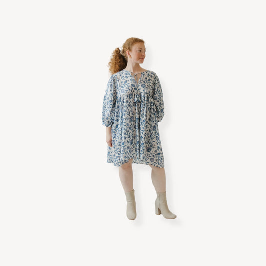 Woman wearing a patterned dress on a white background