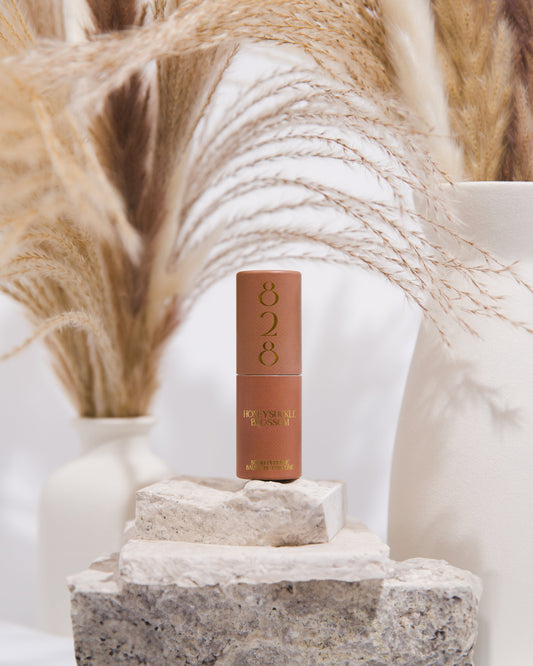 Cosmetic perfume with '828' branding on a stone surface with decorative elements in the background