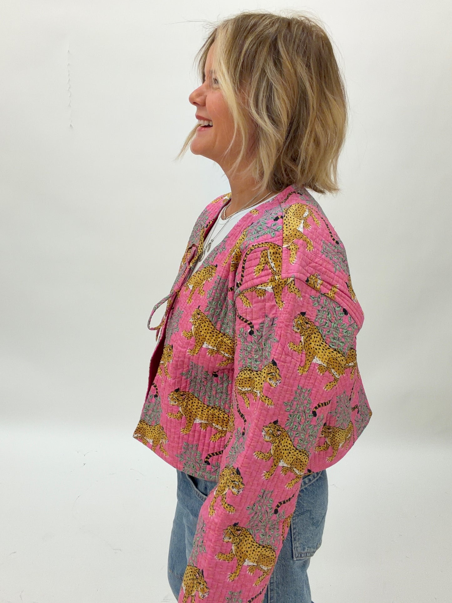 Person wearing a pink patterned jacket with a white background
