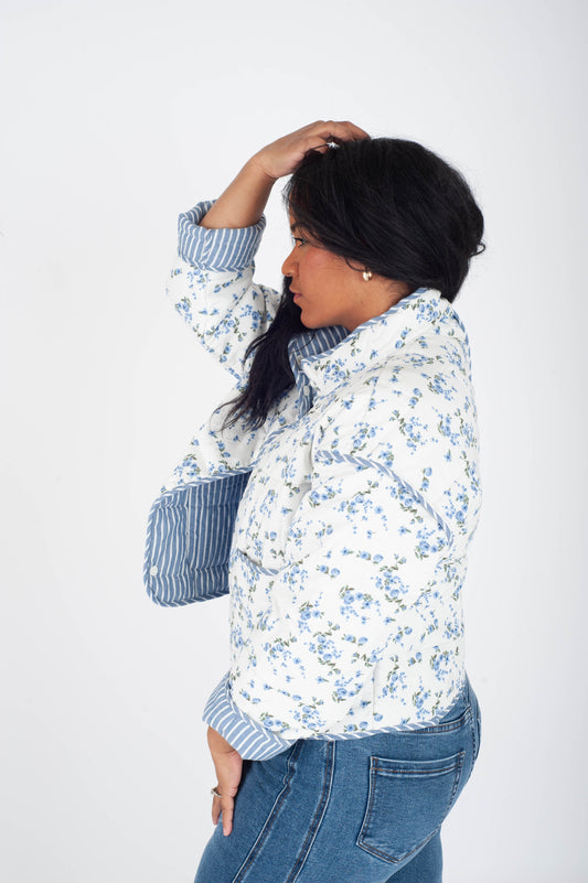 Woman wearing a floral jacket and jeans on a white background