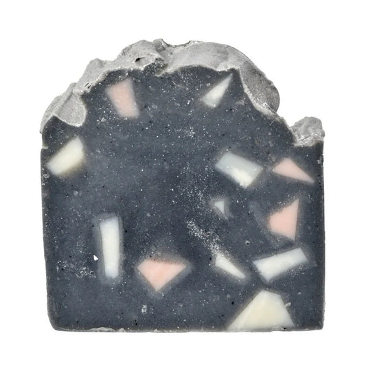 Bar of soap with a textured surface and visible color patterns on a white background