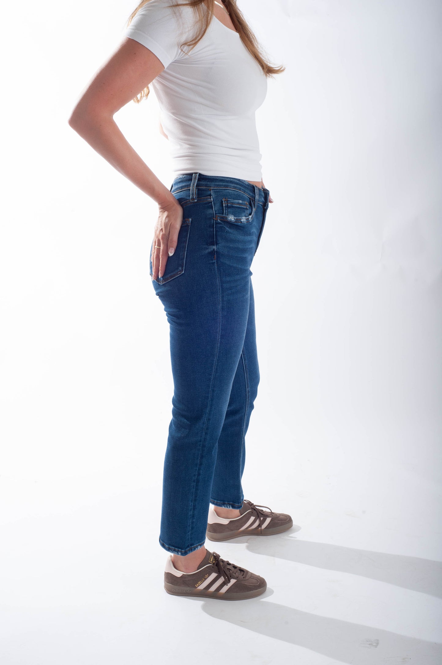 Person wearing blue jeans and a white t-shirt on a white background