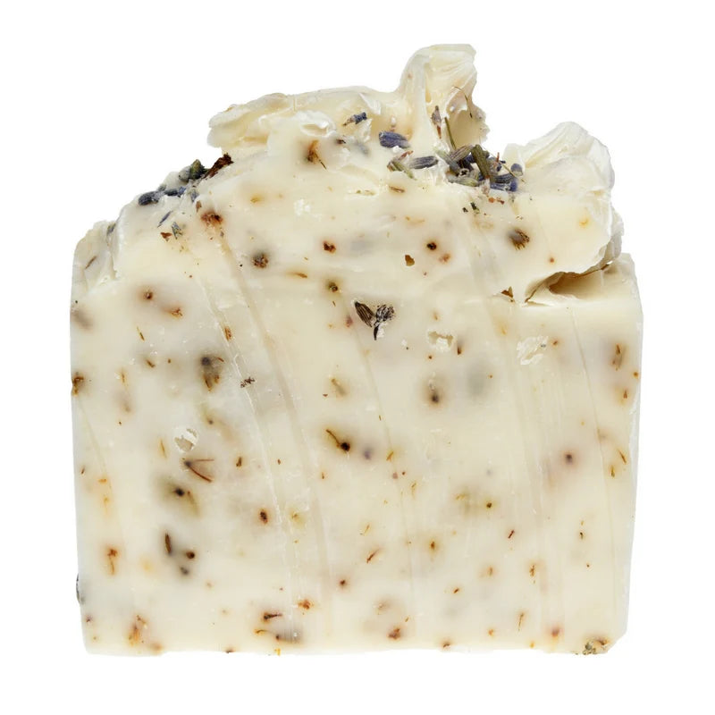 Block of soap with visible herbs on a white background