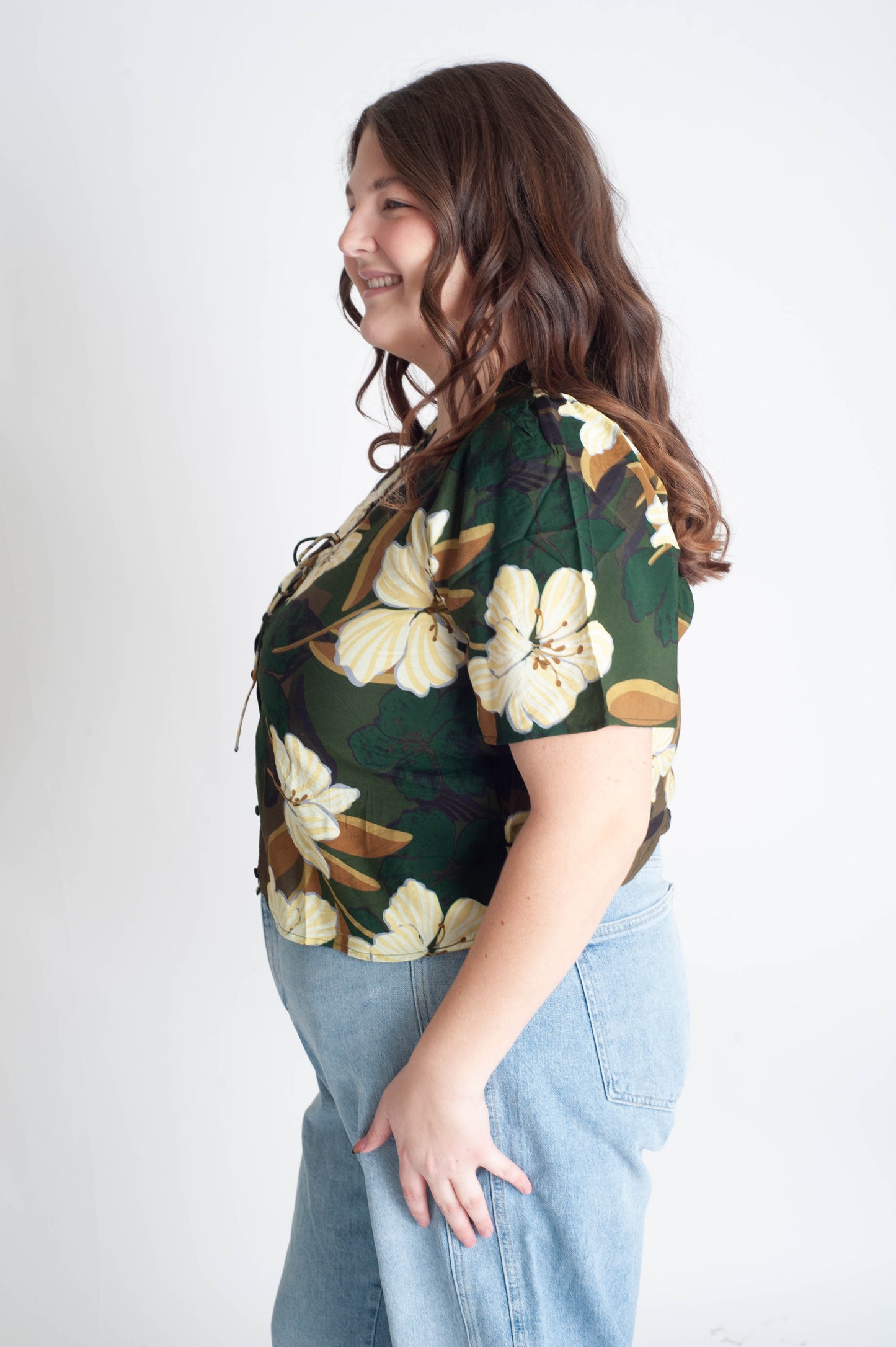 Woman wearing a floral top with a plain background