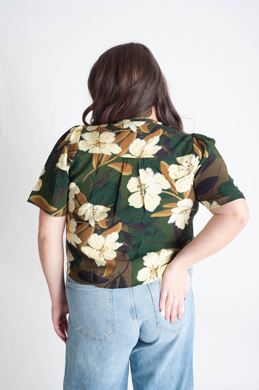 Person wearing a floral blouse with a white background