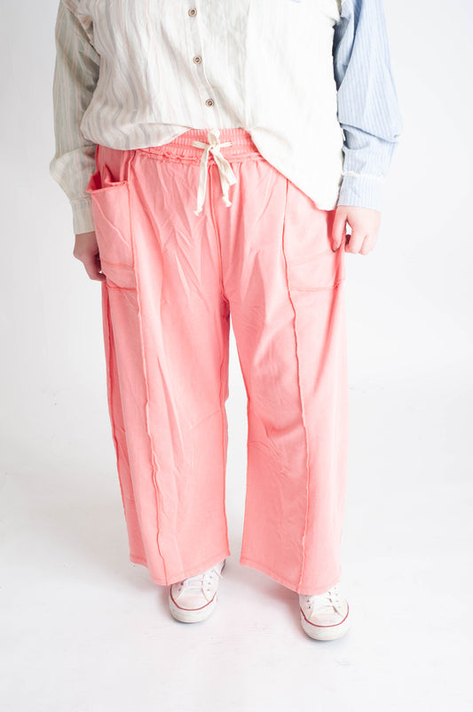 Person wearing pink pants with a white background