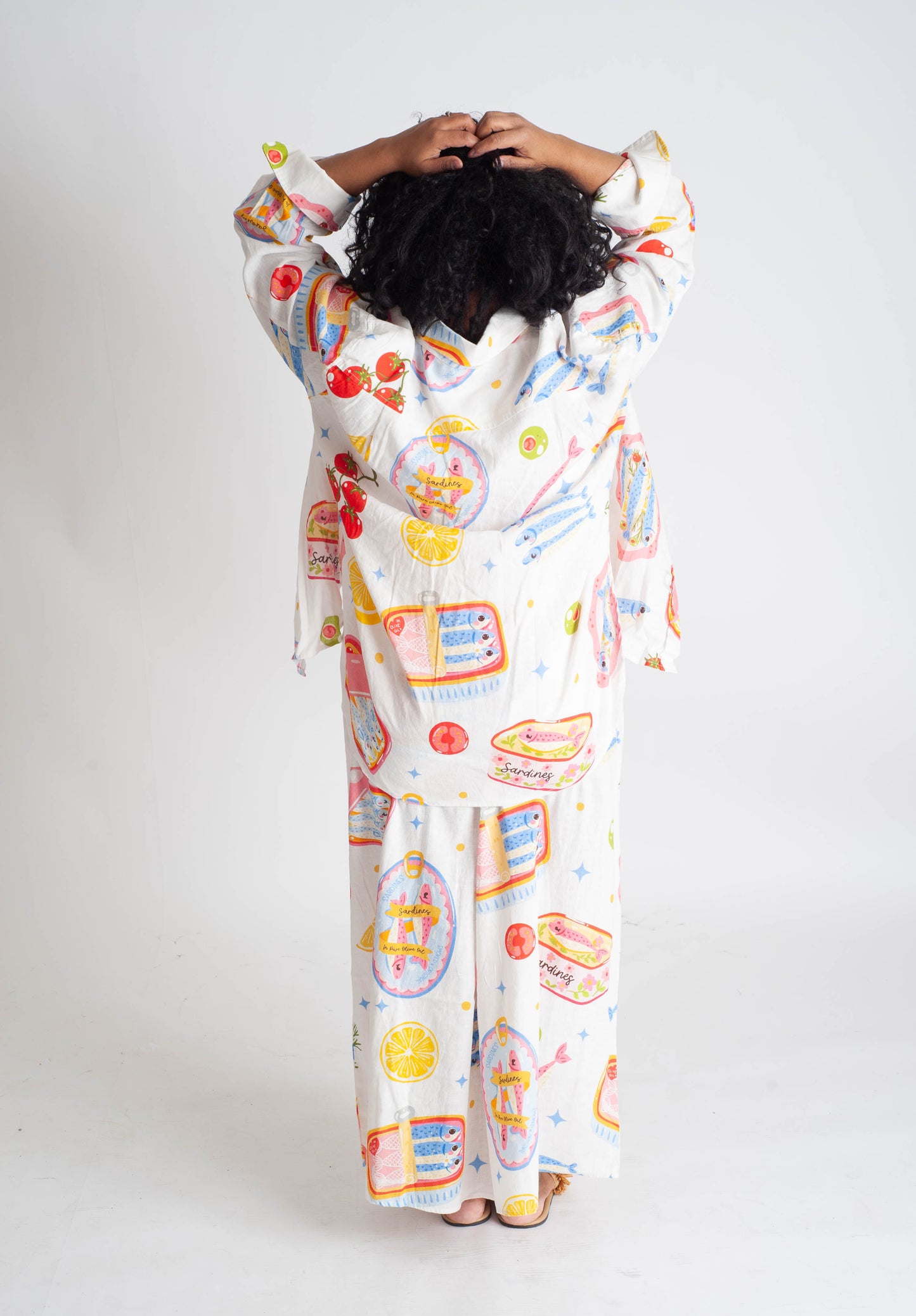 Person wearing a colorful onesie with cartoon designs on a white background