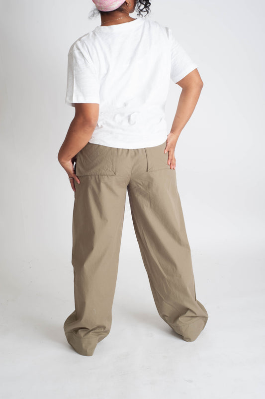 Person wearing a white t-shirt and beige wide-leg pants on a white background