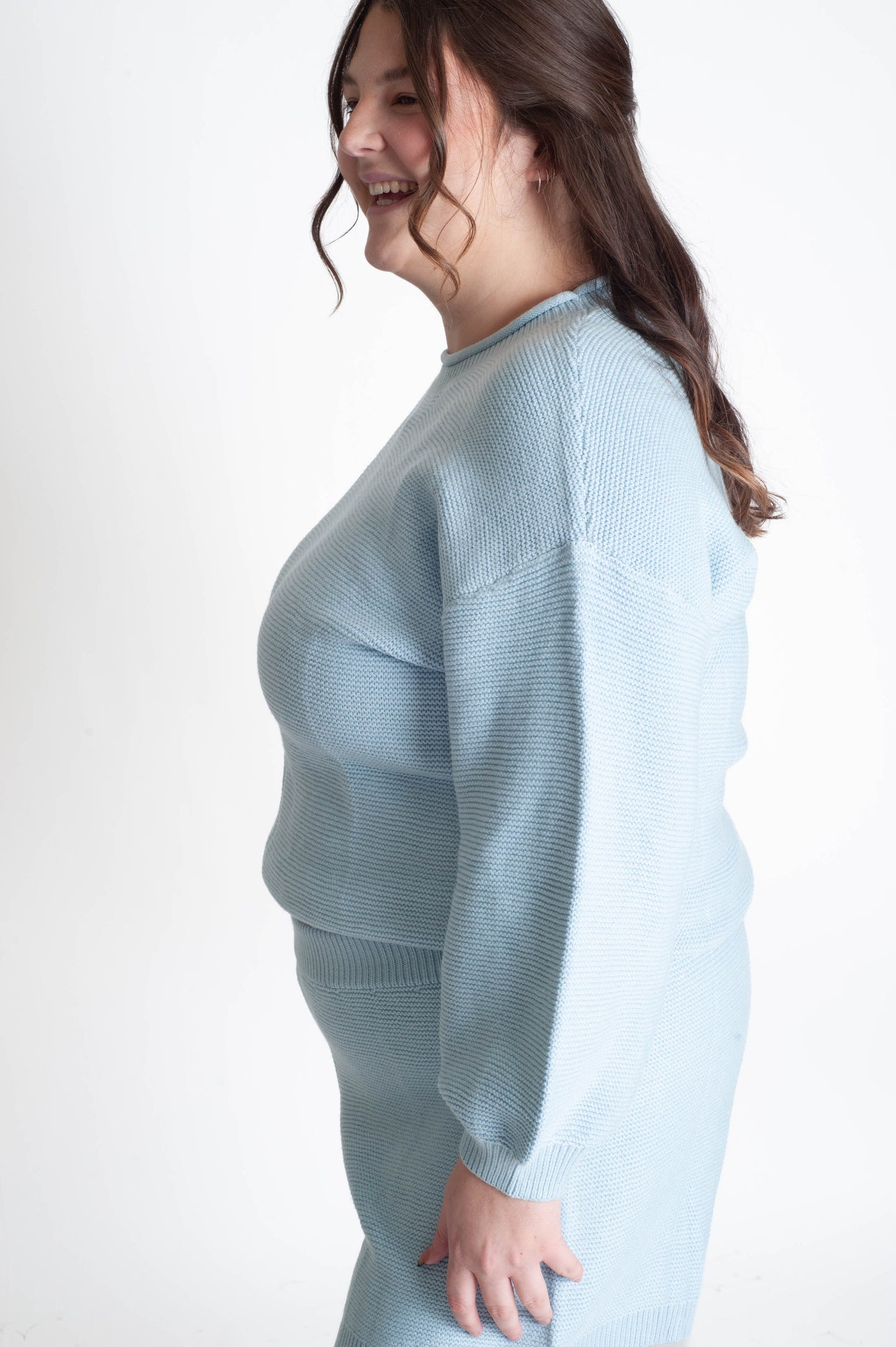 Woman wearing a light blue sweater on a white background