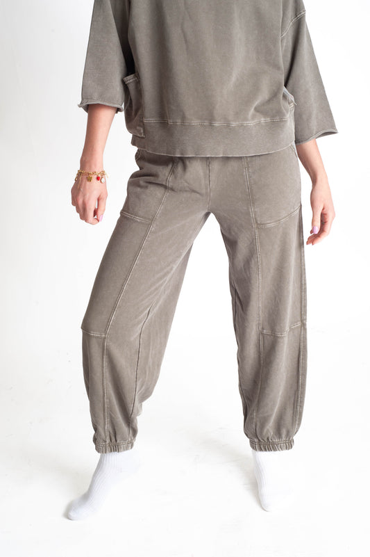 Person wearing a beige outfit with a matching jogger pants on a white background