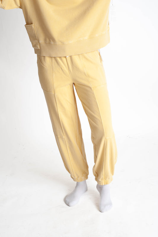 Yellow tracksuit worn by a person on a white background