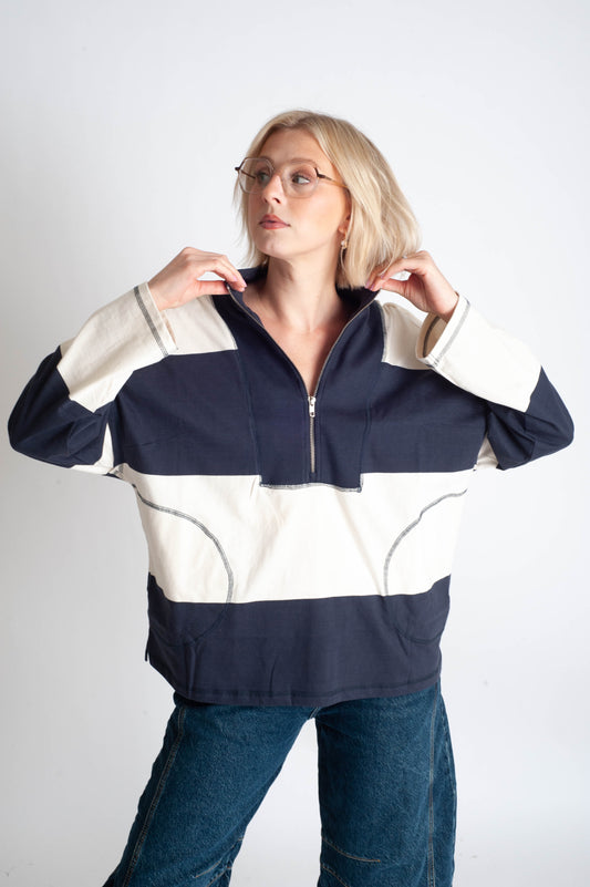 Person wearing a navy and white striped jacket on a plain background