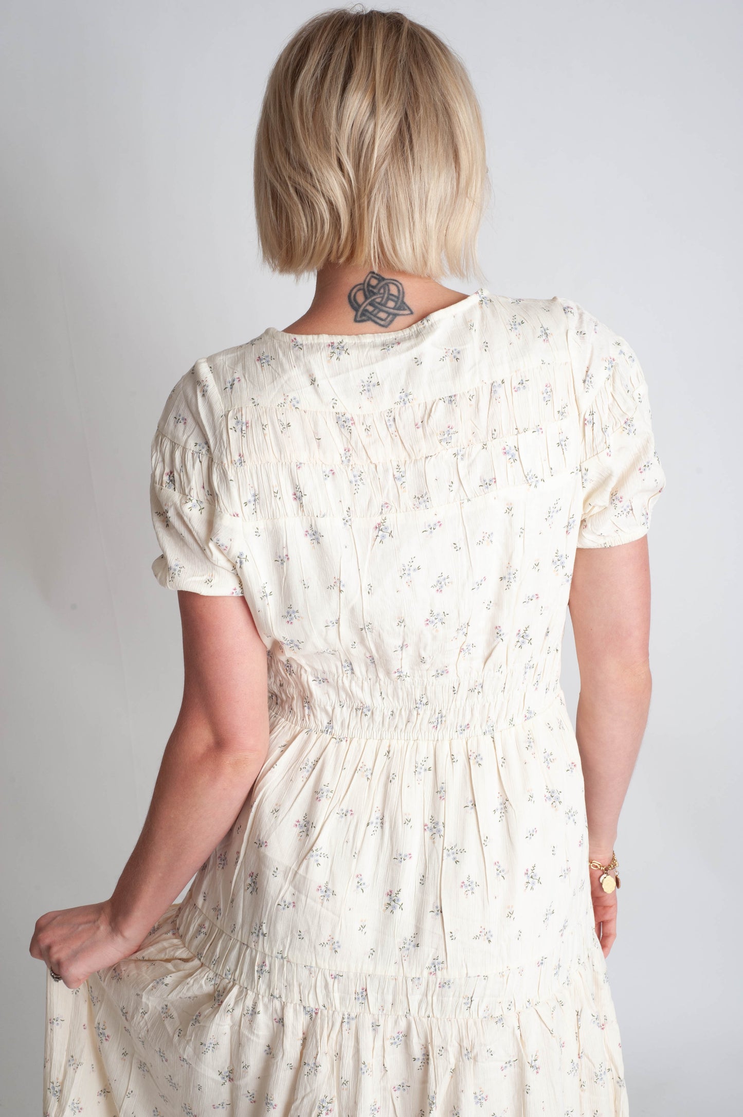 Person wearing a floral dress with a plain background
