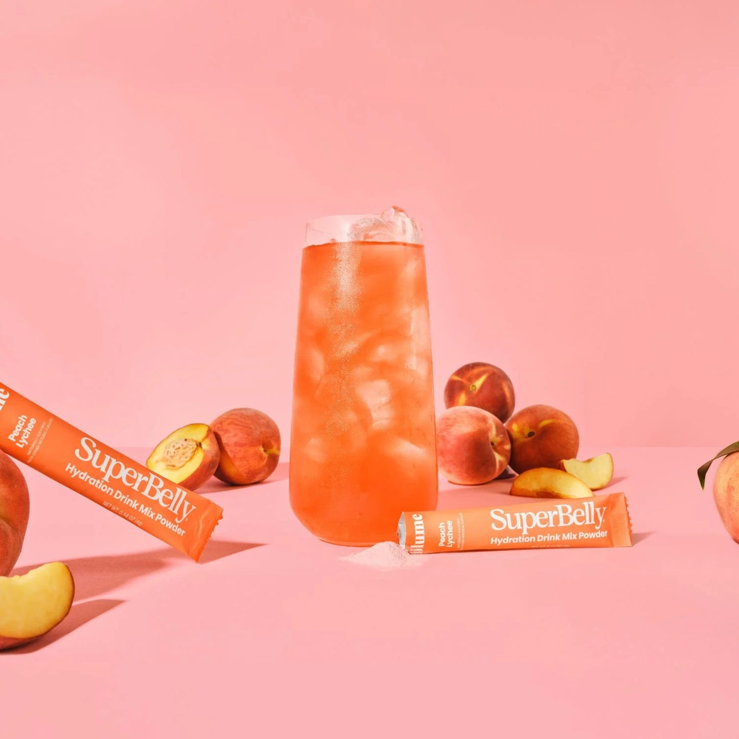 SuperBelly drink mix with peach slices on a pink background