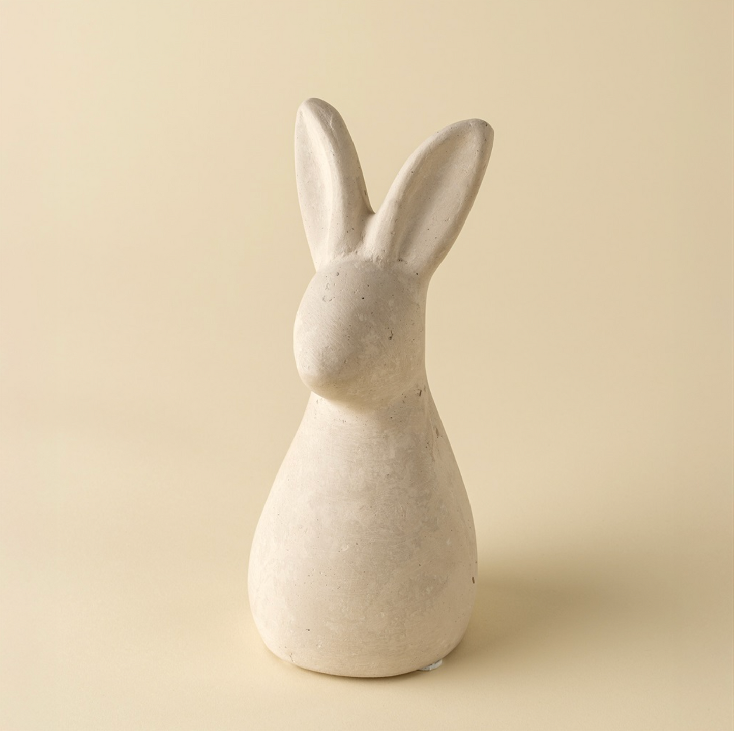 White ceramic rabbit sculpture on a beige background
