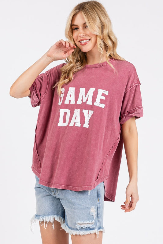 Woman wearing a 'GAME DAY' t-shirt and denim shorts on a white background