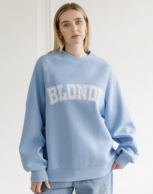 Person wearing a light blue sweatshirt with 'BLONDE' text on a white background