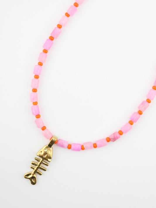 Necklace with pink beads and gold fish bone charm on a white background