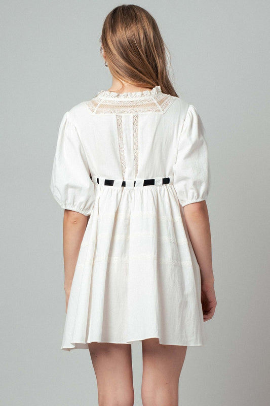 White dress with lace details on a gray background