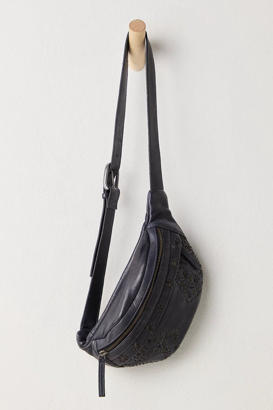 Black textured waist bag hanging on a wooden hook against a light gray background