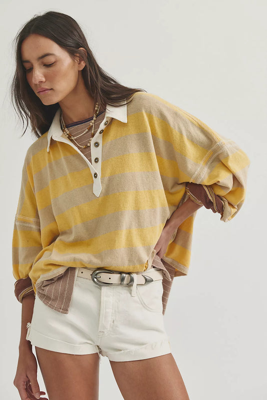 Woman wearing a yellow and beige striped shirt with white shorts on a white background