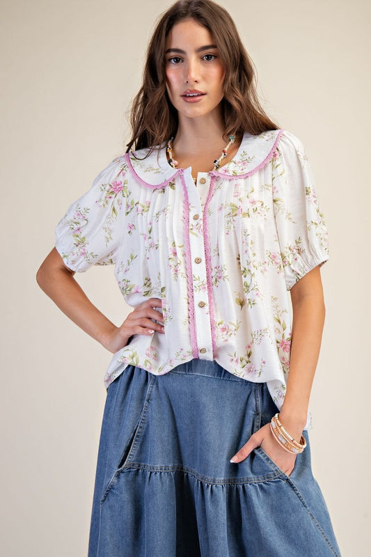 Woman wearing a floral blouse and denim skirt on a beige background