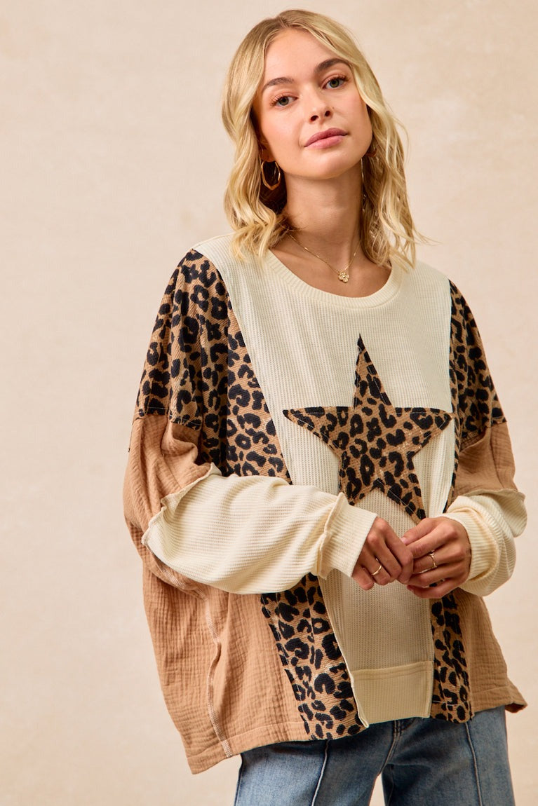 Woman wearing a sweater with leopard print and star design on a beige background